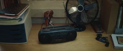 a radio sitting on a desk next to a fan