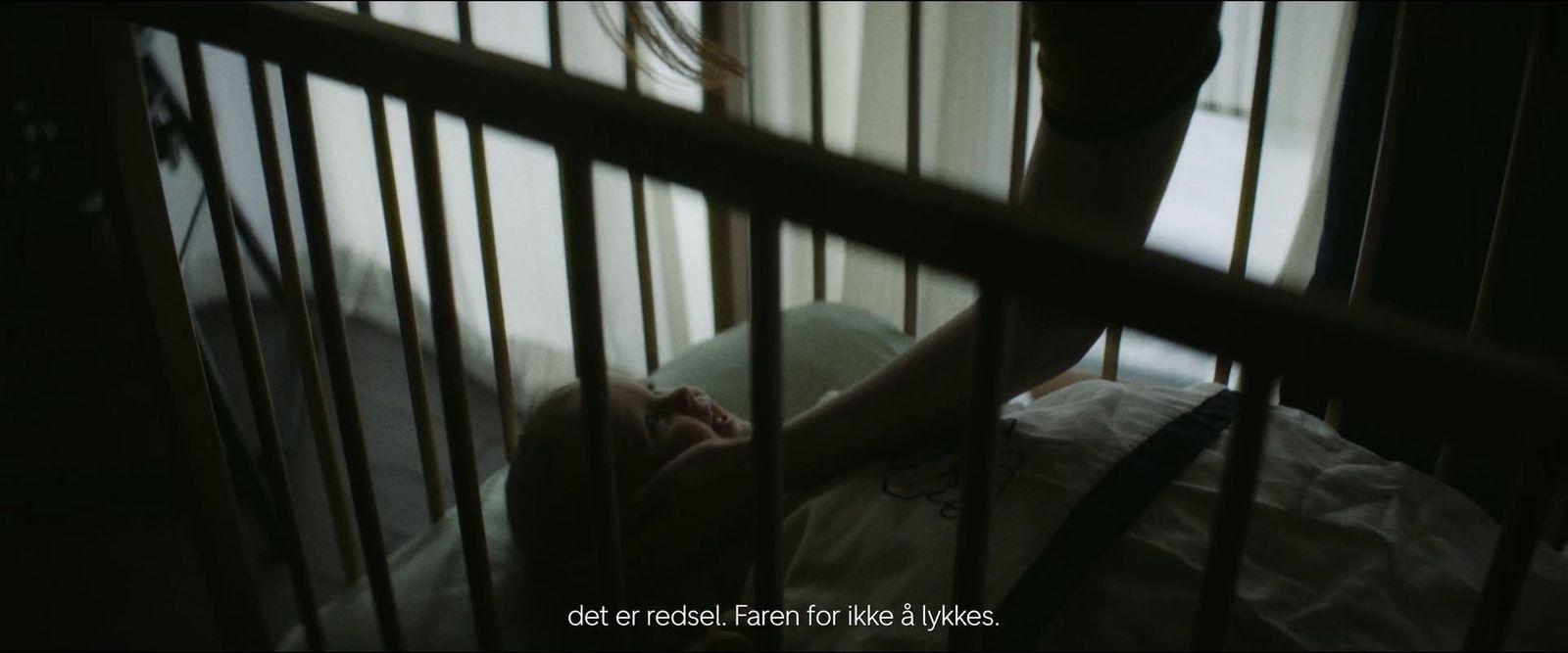 a person laying in a crib in a dark room