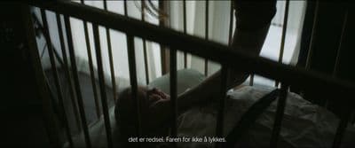 a person laying in a crib in a dark room