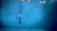 a person swimming under water in a pool