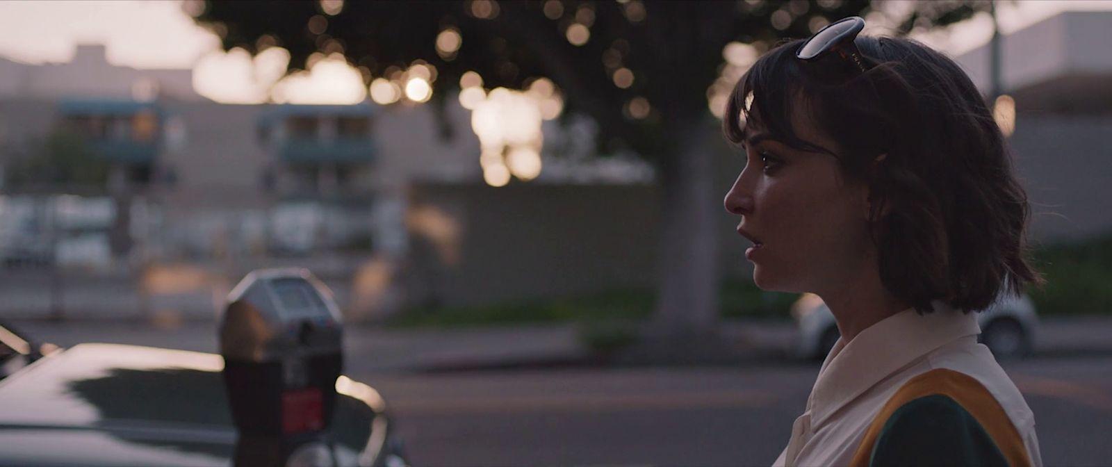 a woman standing next to a parking meter