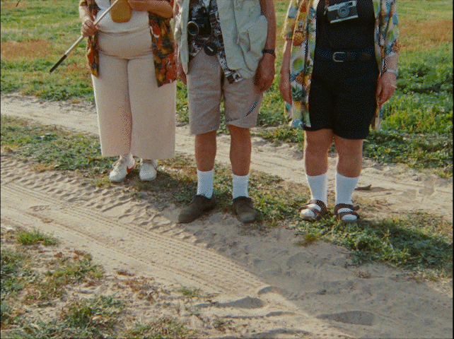a group of people standing next to each other on a dirt road