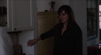 a woman standing in a kitchen with her hand out