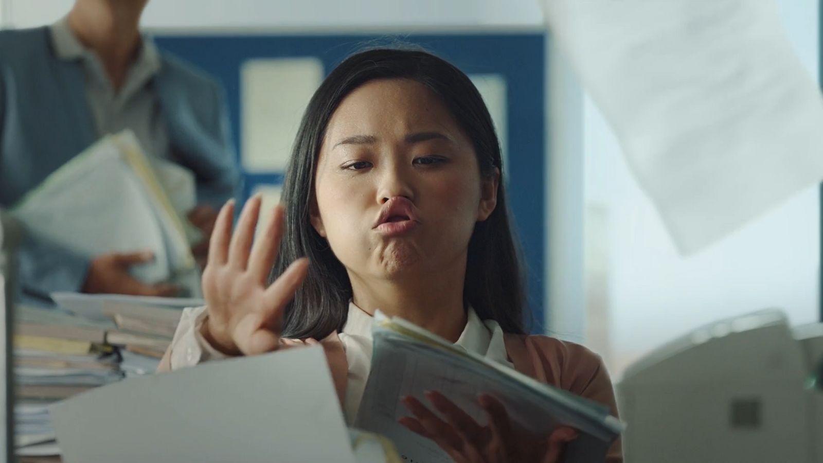 a woman holding a folder and making a hand gesture