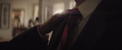 a man in a suit and tie standing in a room