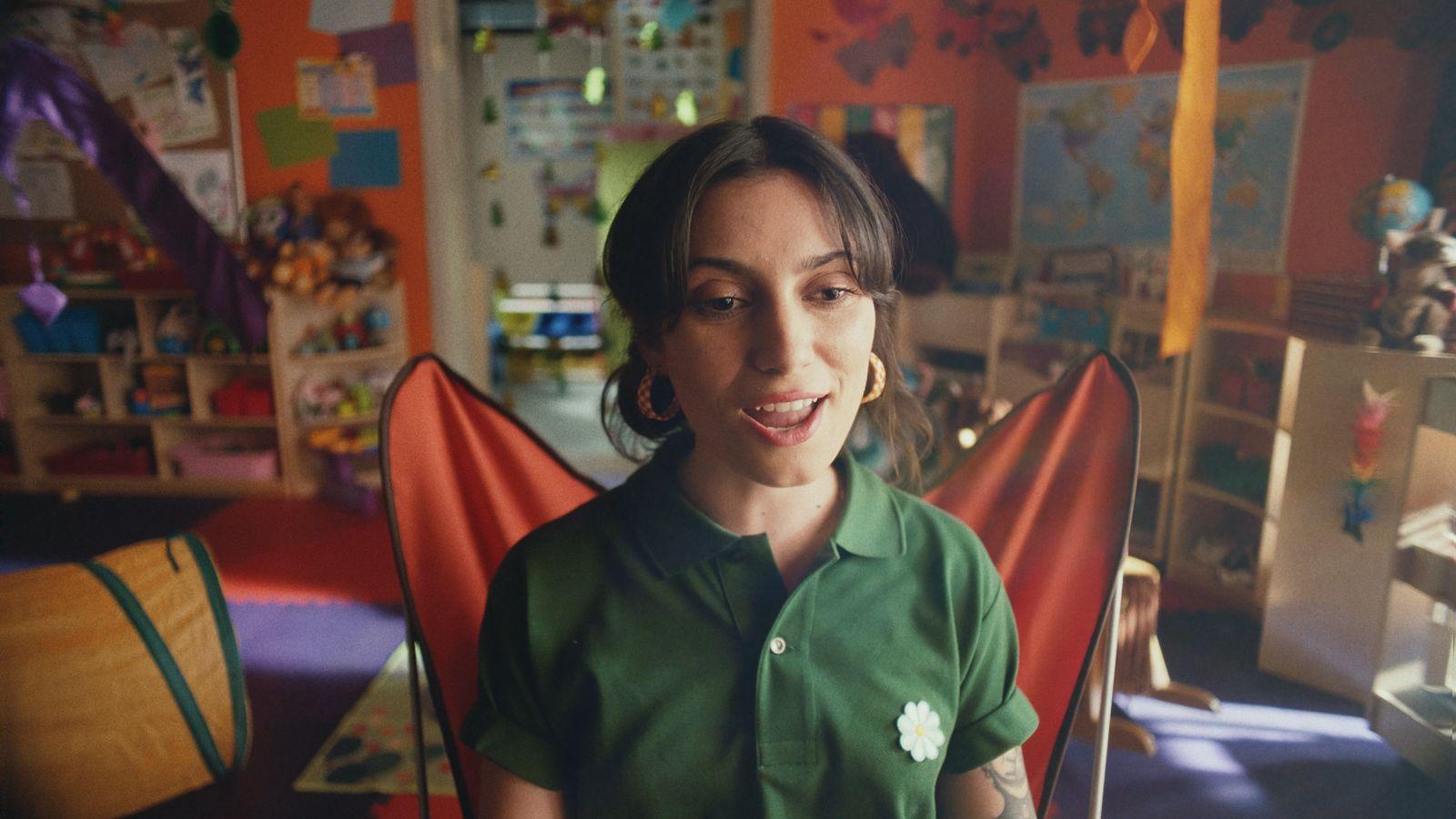a woman in a green shirt sitting in a room