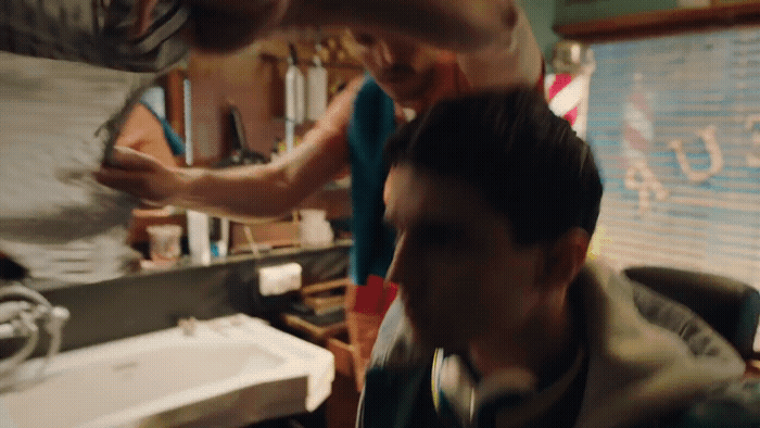 a man getting his hair cut in a barber shop