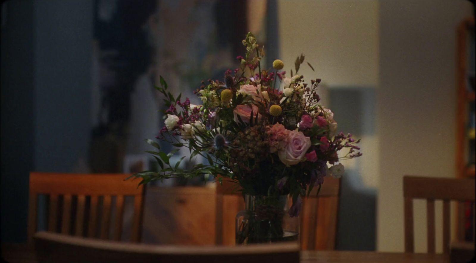 a vase filled with flowers sitting on top of a wooden table