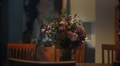 a vase filled with flowers sitting on top of a wooden table