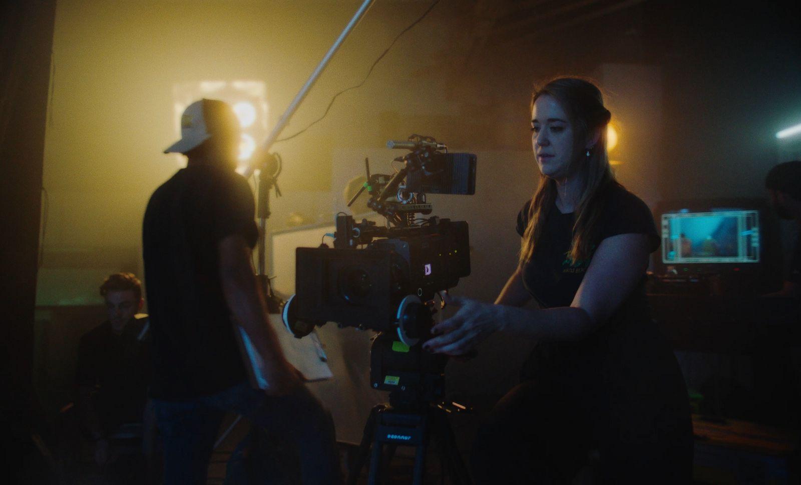 a woman standing next to a man holding a camera