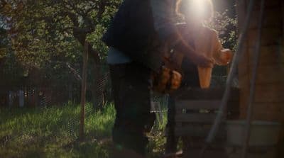 a man standing next to a dog on top of a lush green field
