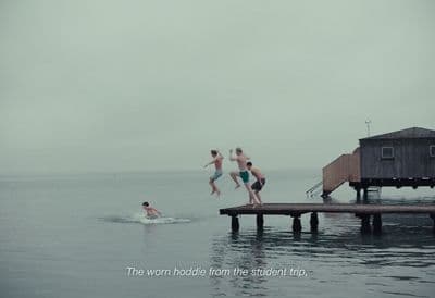 a group of people jumping off a dock into the water