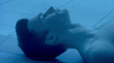 a man laying on the floor with his head in the air