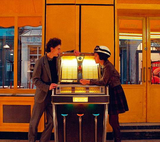 a man and a woman standing next to a vending machine