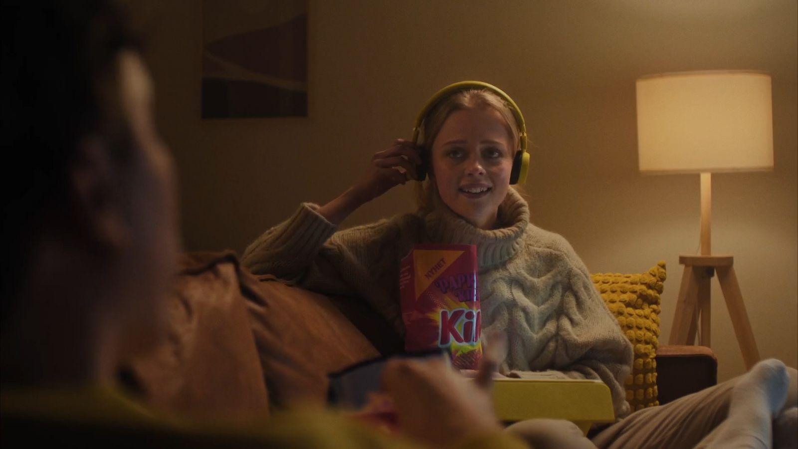 a woman sitting on a couch with headphones on