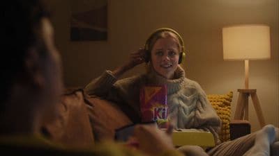 a woman sitting on a couch with headphones on