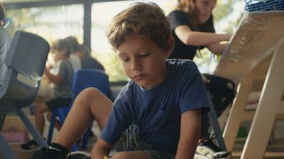 a young boy sitting on a chair in a room