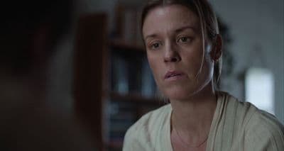 a woman in a white shirt looking at a man