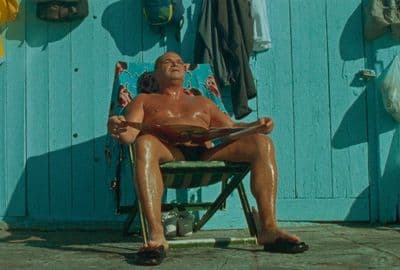 a man sitting in a chair on the beach