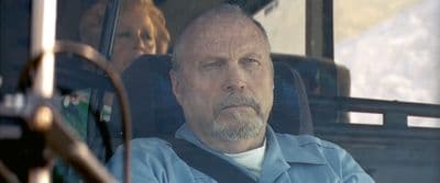 a man sitting in a bus looking out the window