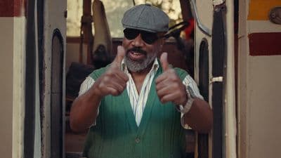 a man in a green shirt giving a thumbs up