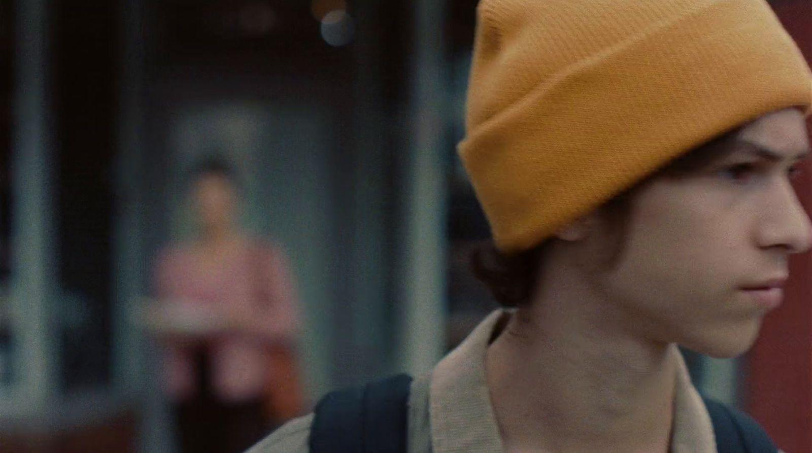 a young man wearing a yellow hat and backpack