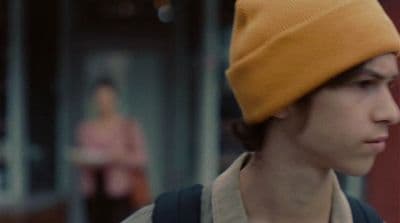 a young man wearing a yellow hat and backpack