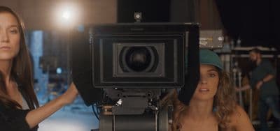 two women standing in front of a camera