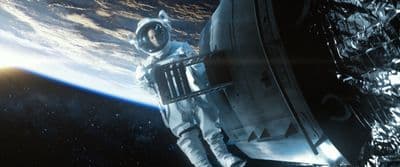 a man in a space suit standing in front of a space station