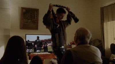 a man standing in front of a tv holding a tie