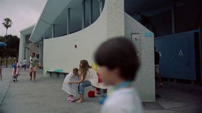 a group of children sitting on a bench in front of a building