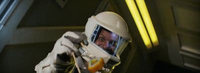 a man in a space suit holding an orange