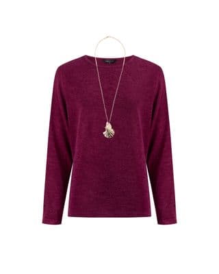 a woman wearing a purple sweater and a necklace