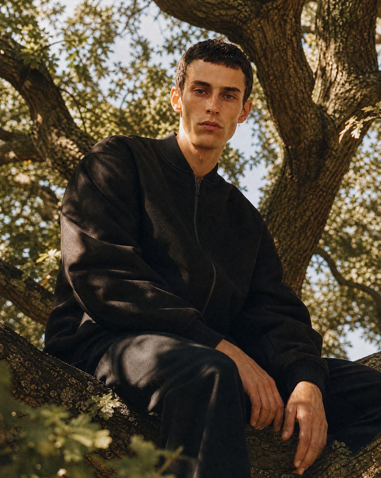 a man sitting in a tree with his legs crossed
