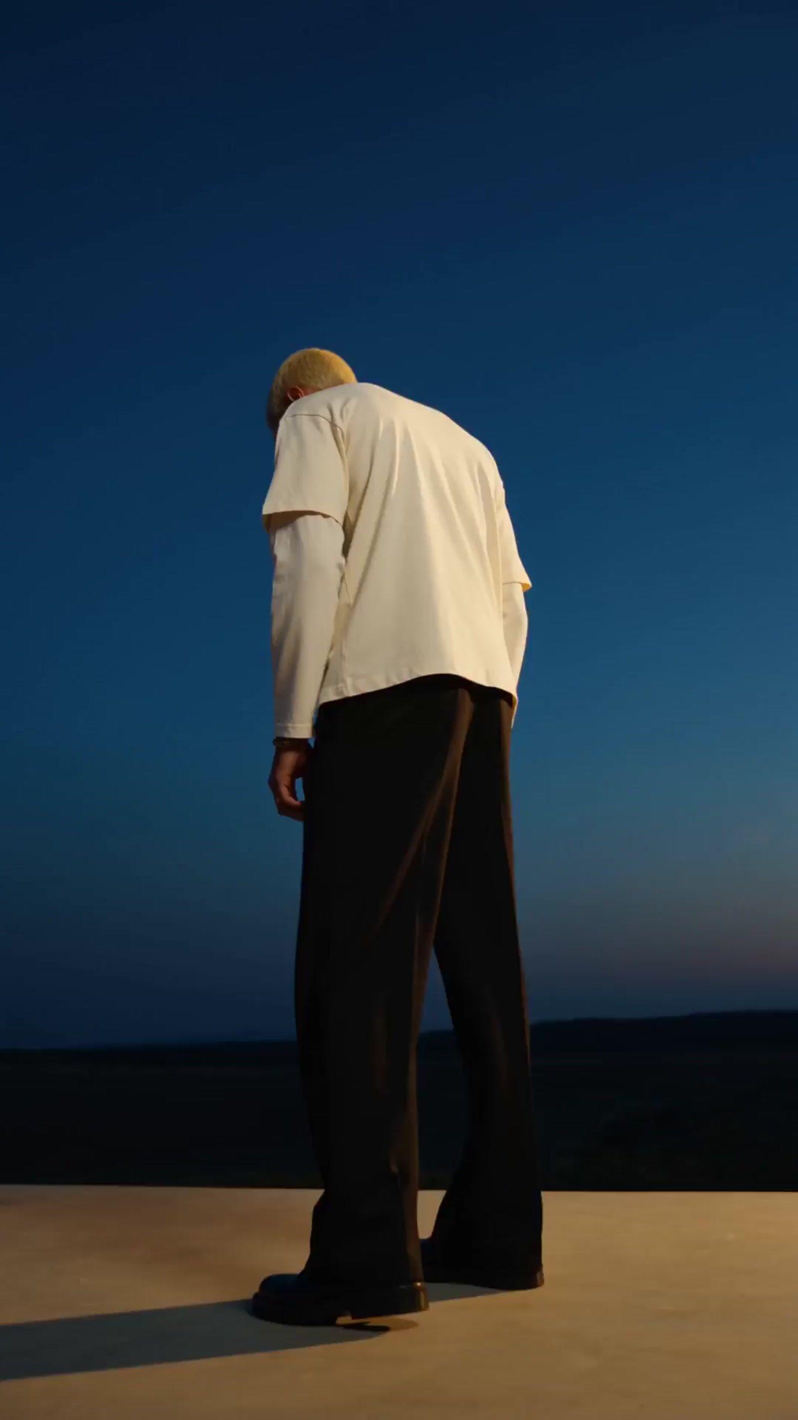 a man in a white shirt and black pants