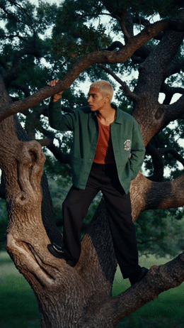 a man in a green jacket standing on a tree