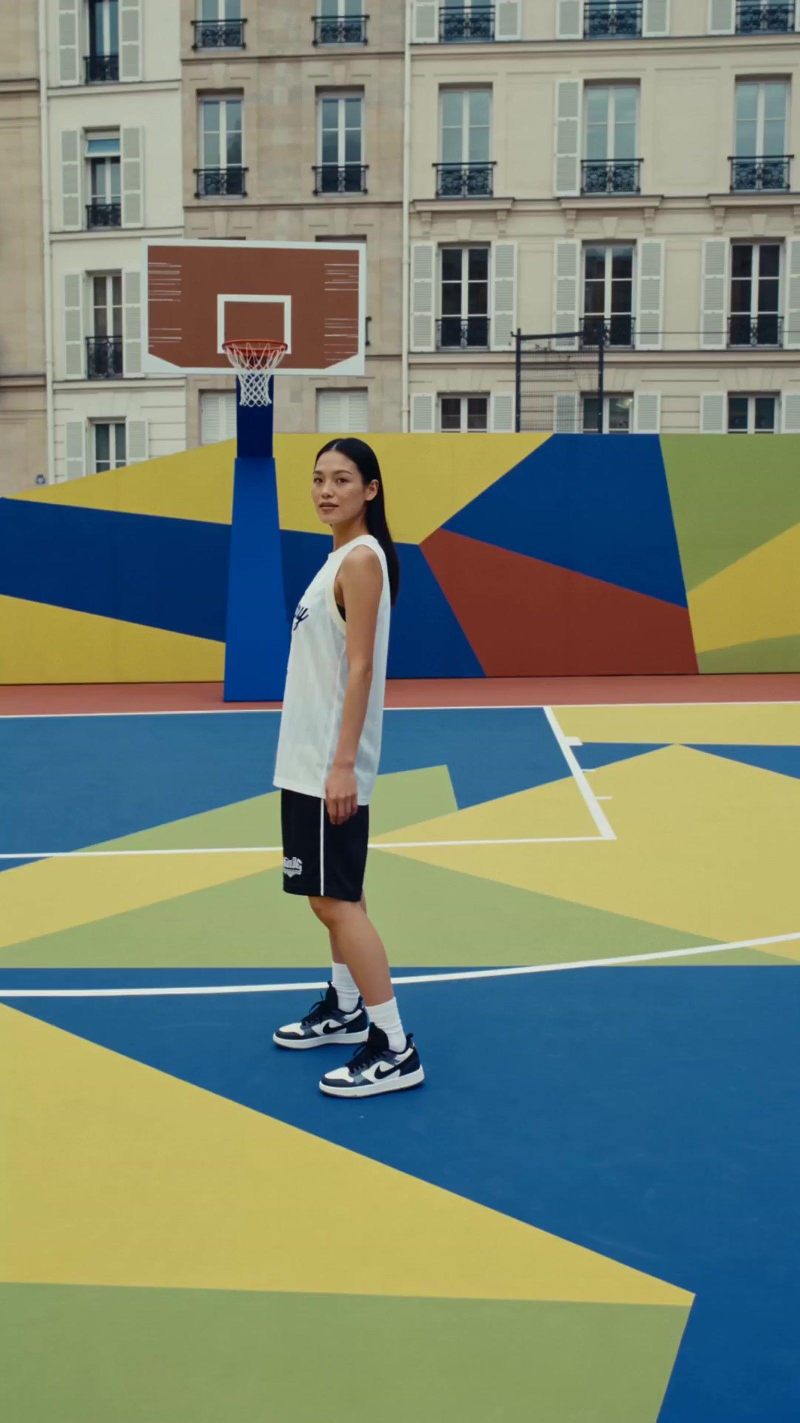 a person standing on a court with a basketball hoop