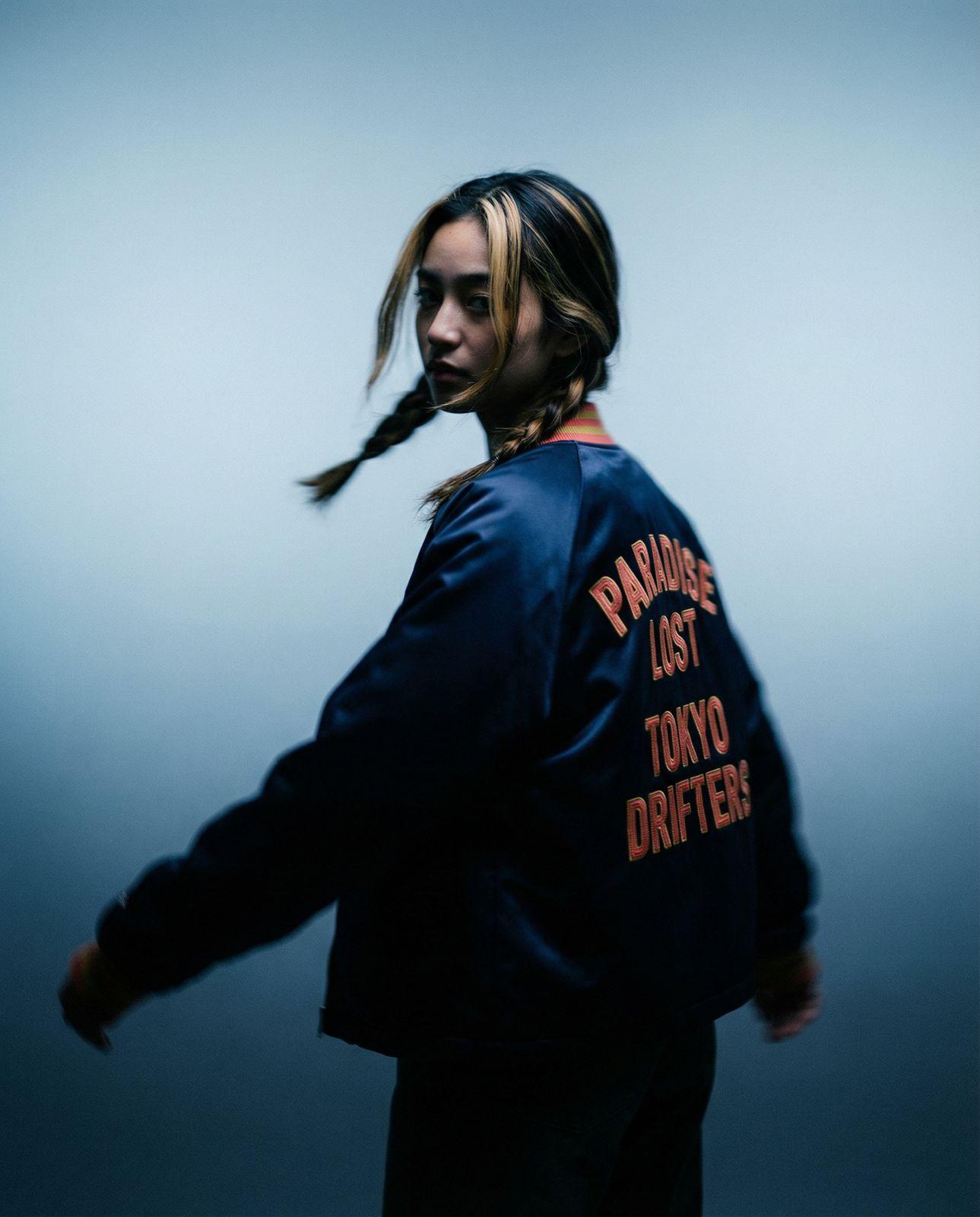 a man with long hair wearing a blue jacket