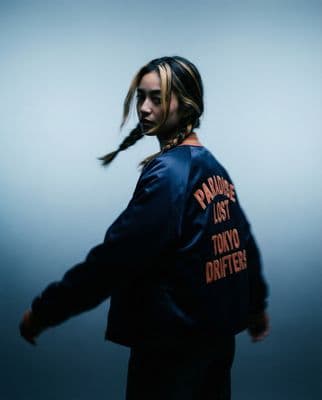 a man with long hair wearing a blue jacket