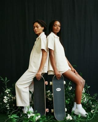 two young women sitting on top of skateboards