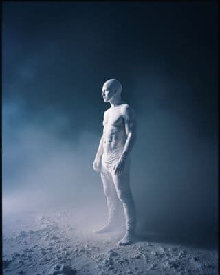 a white mannequin standing in the snow