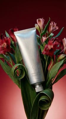 a vase filled with flowers and a tube of cream