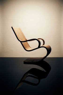 a wooden chair sitting on top of a black table