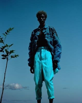 a statue of a man standing next to a tree