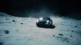 a car driving on a snowy surface at night