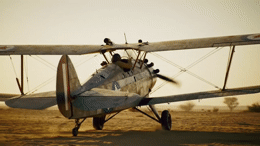 a small airplane sitting on top of a dirt field