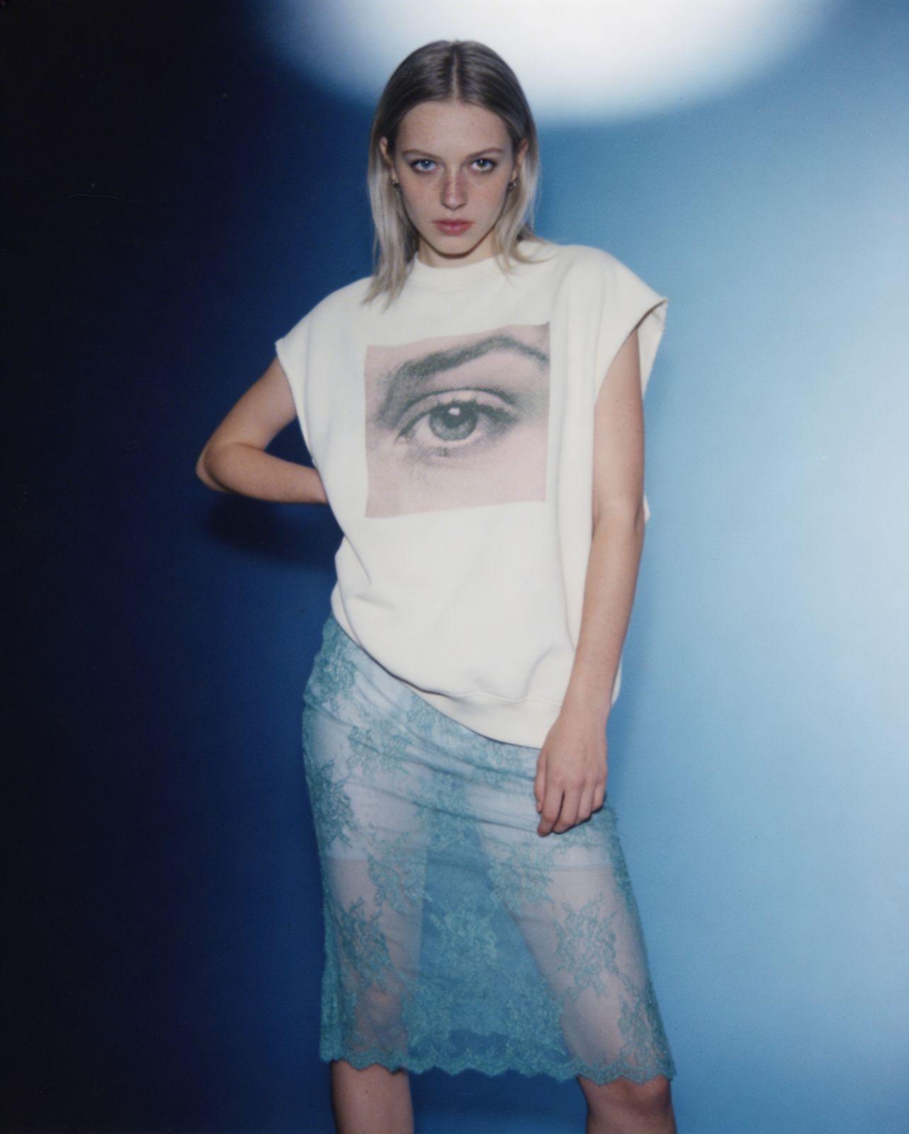 a woman standing in front of a blue background