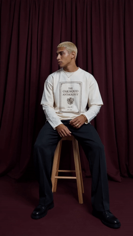 a man sitting on top of a wooden stool