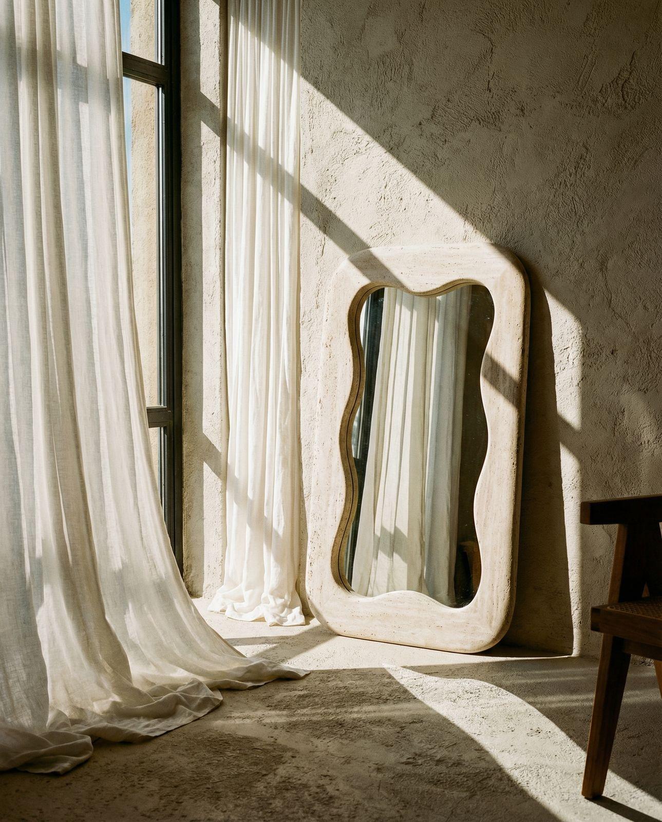 a mirror sitting on top of a table next to a window