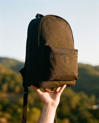 a person holding a backpack up to their face